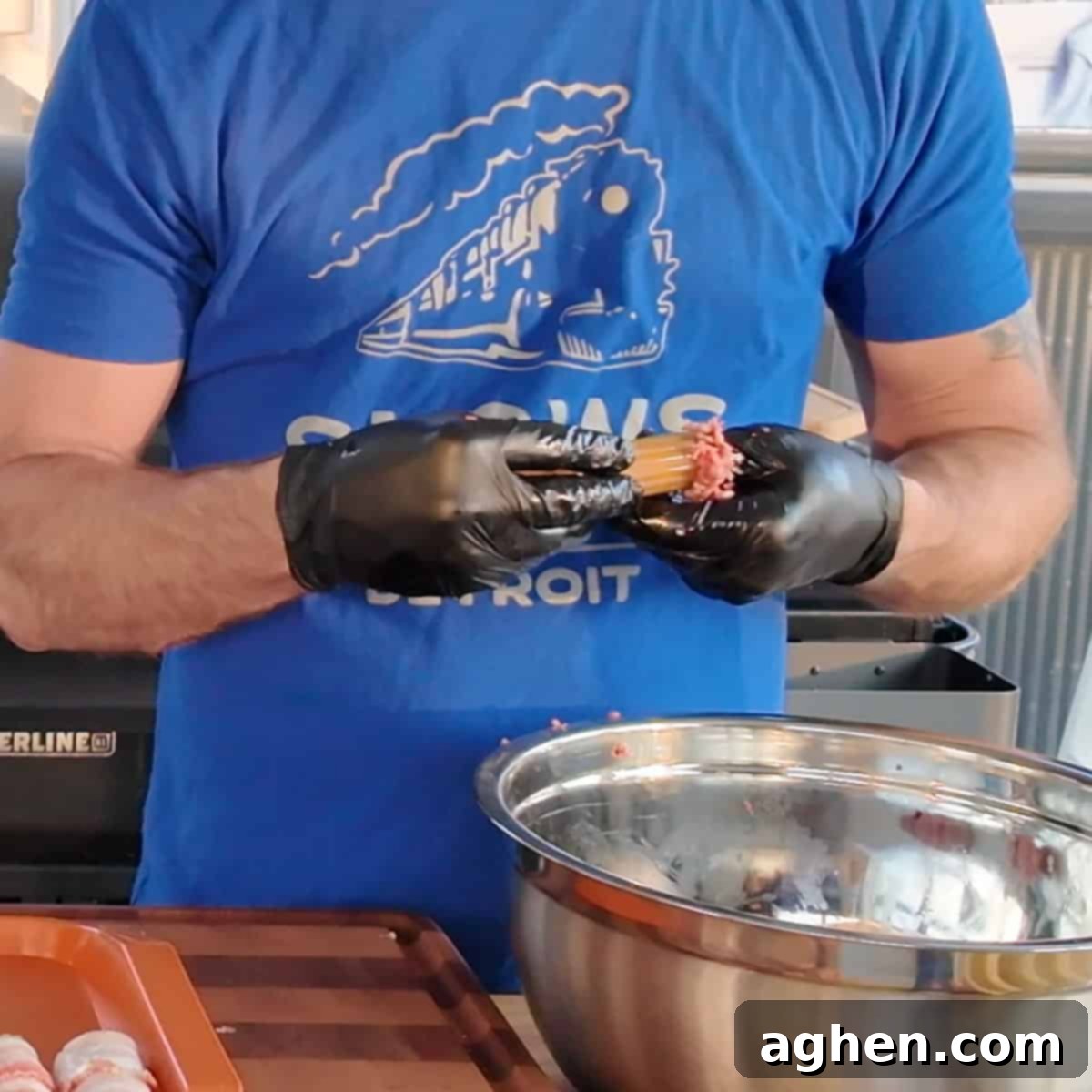 Close-up of manicotti shells being stuffed with seasoned ground meat by hand