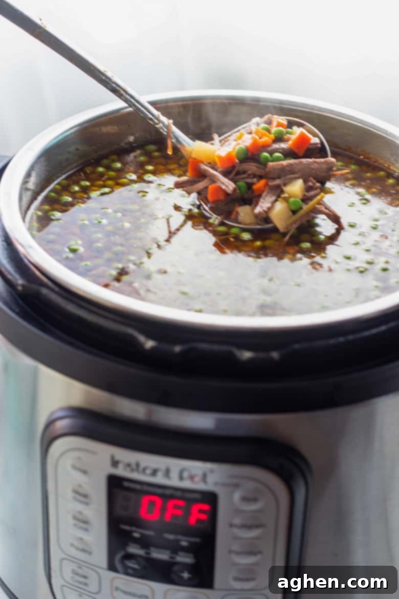 Vegetable Beef Soup cooking inside an Instant Pot pressure cooker, showing the rich broth and ingredients