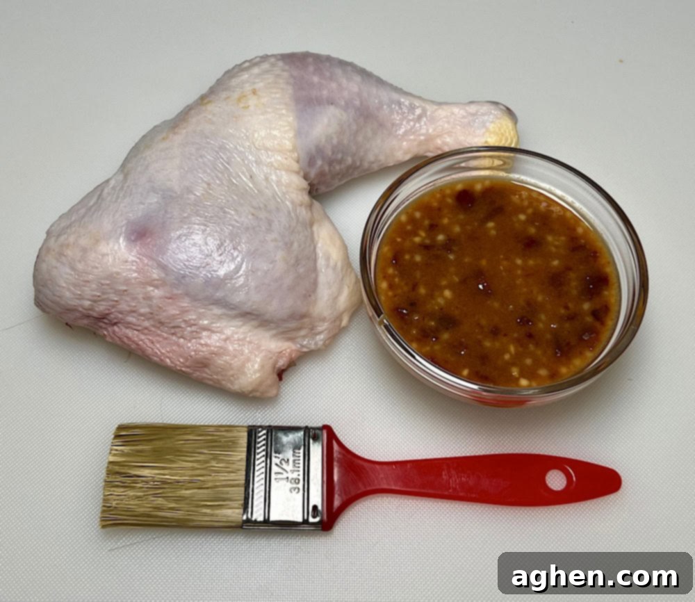 Preparing to put honey chipotle glaze on chicken with a basting brush.