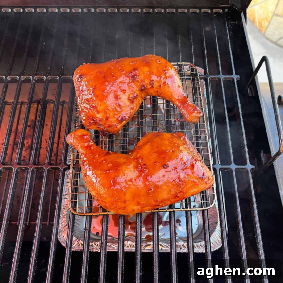 Perfectly smoked honey glazed chicken leg quarter resting on the smoker grill.