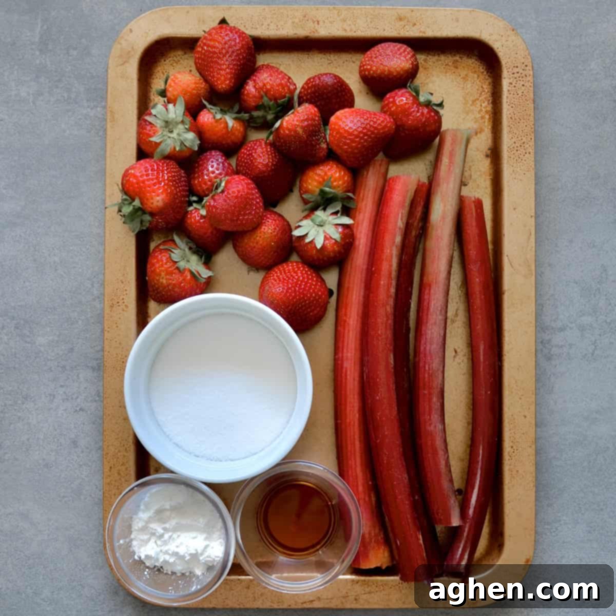Guilt-Free Strawberry Rhubarb Crisp 3 Group of fresh ingredients for strawberry rhubarb crisp filling, including strawberries, rhubarb, sweetener, cornstarch, and vanilla extract