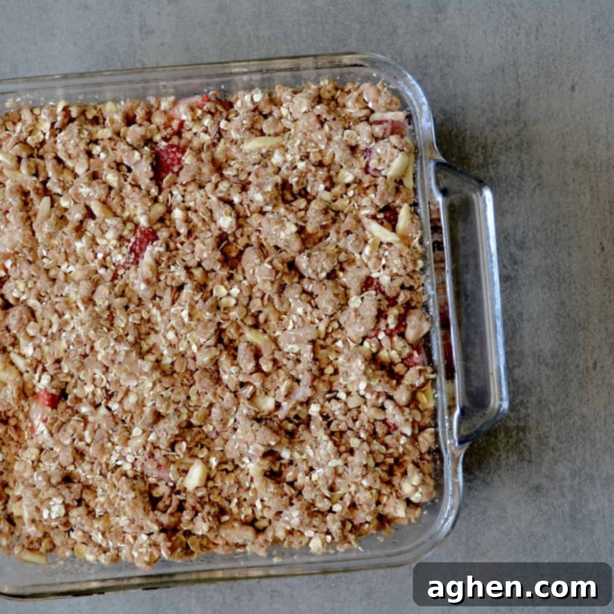 Guilt-Free Strawberry Rhubarb Crisp 5 Unbaked strawberry rhubarb crisp in a square baking dish, topped with golden oat streusel