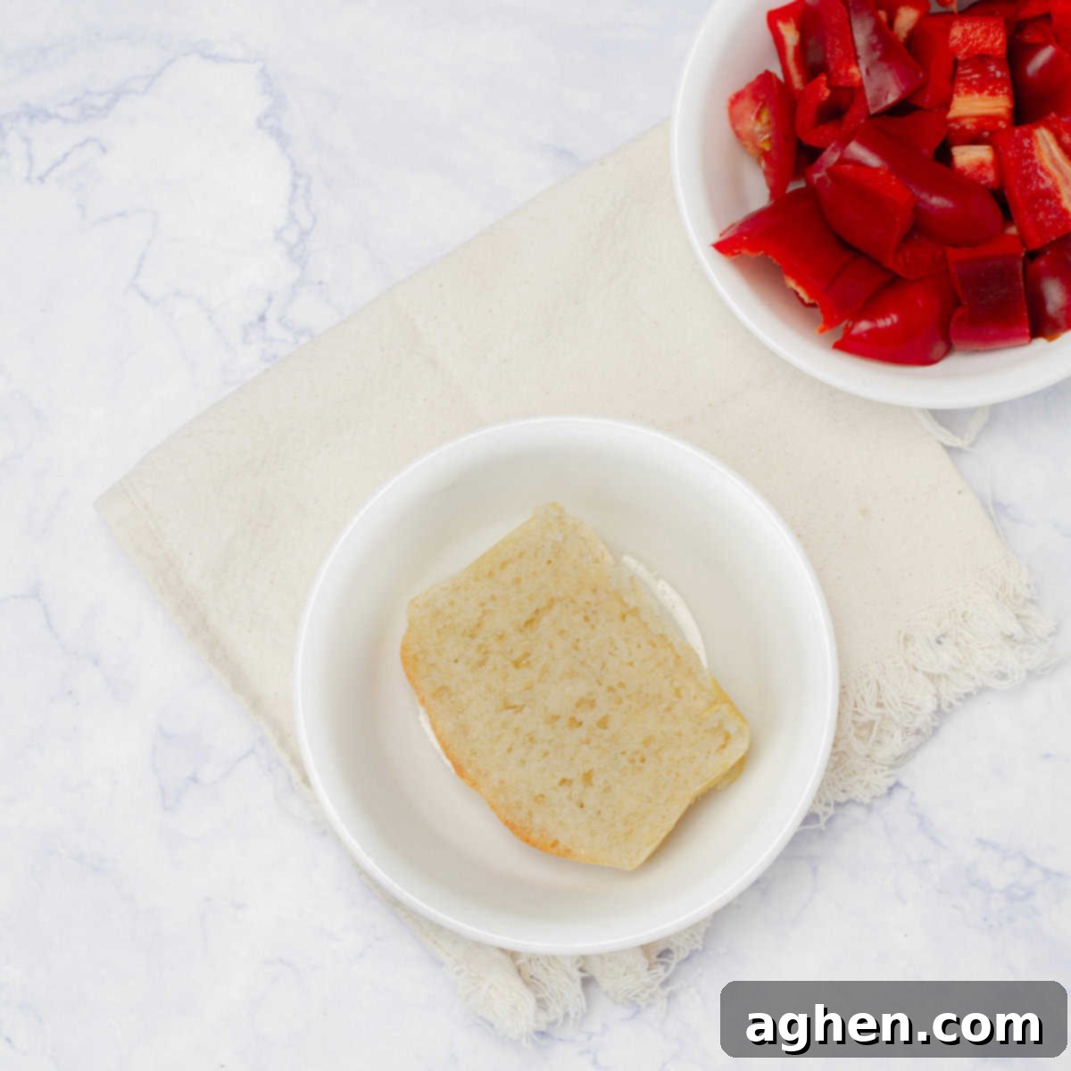A piece of bread soaking in a bowl of olive oil. 