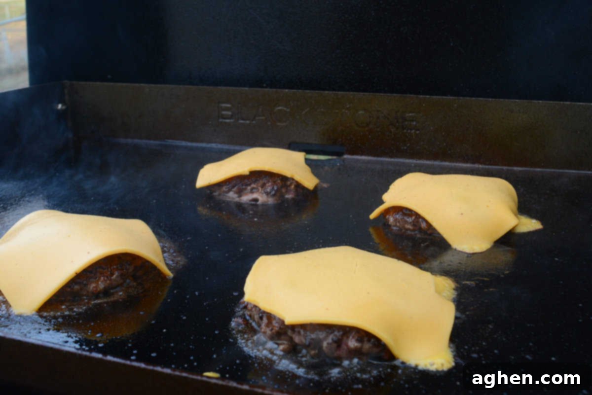 Sizzle Your 4th: Essential Blackstone Recipes for a Spectacular Celebration 12 cheese melting on burger on blackstone grill