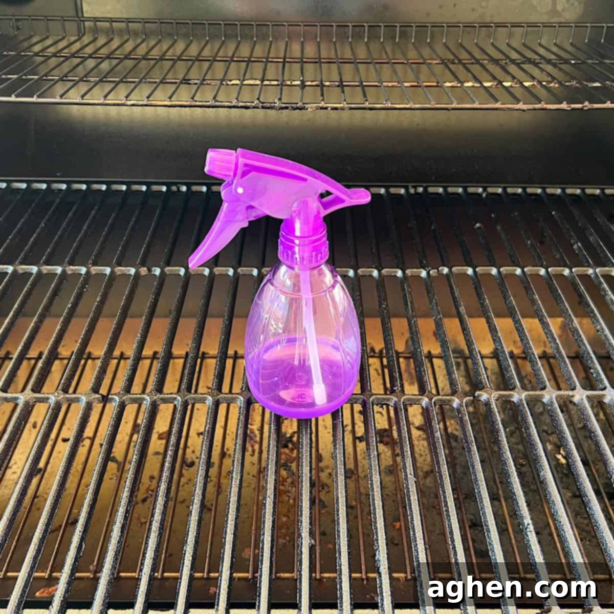 Six Grilling Essentials: What's On Your List? 8 A person using a spray bottle to spritz meat on a barbecue grill, adding moisture and preventing flare-ups.