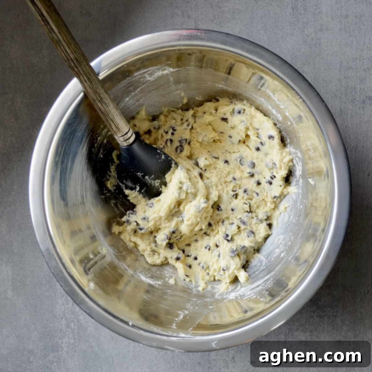 A bowl of fresh cookie dough studded with dark chocolate chips, ready for scooping and baking into delicious treats.