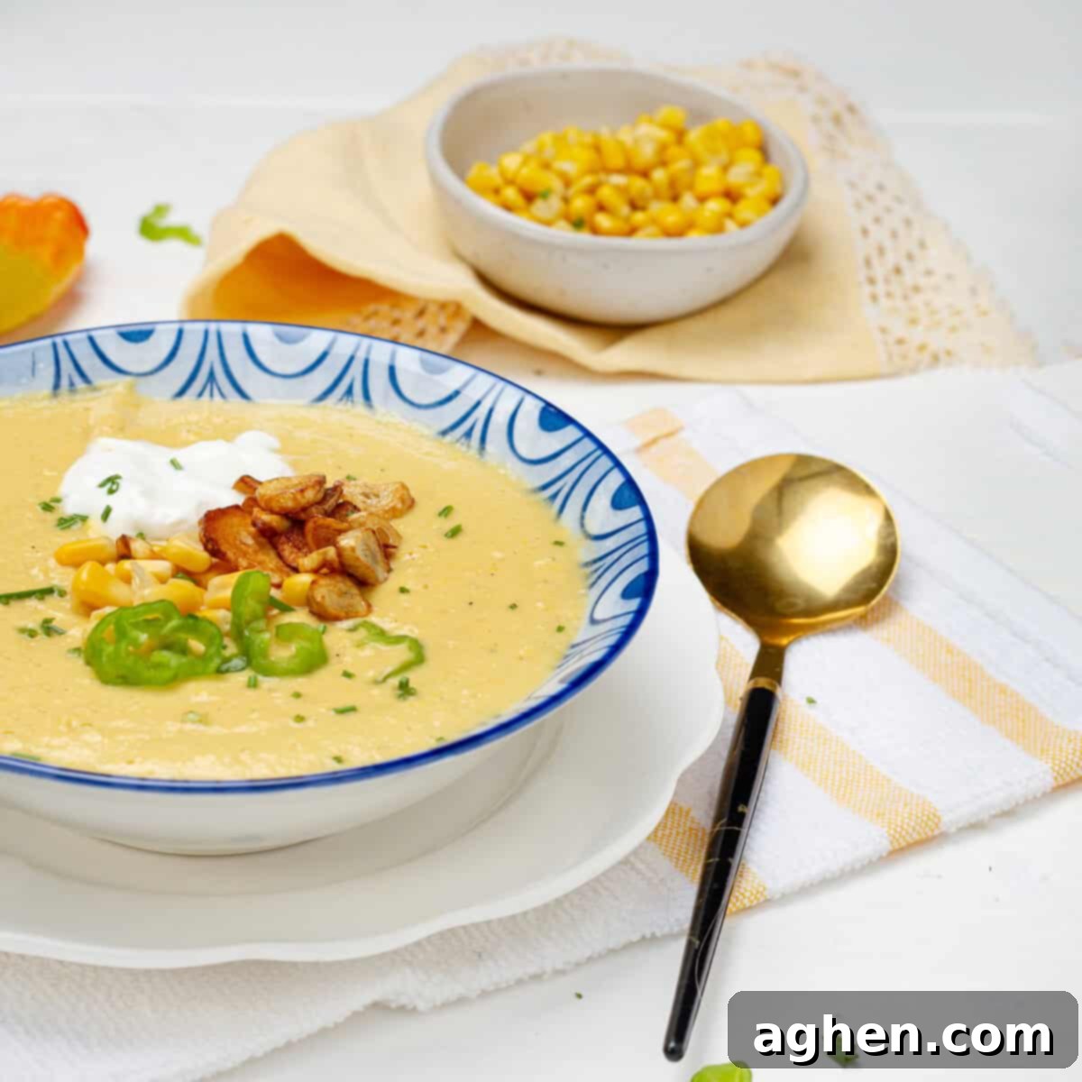 Comforting Mexican Street Corn Soup 2 A beautifully presented bowl of Creamy Mexican Corn Soup, garnished with fresh cilantro and a swirl of Greek yogurt, with a spoon for serving.