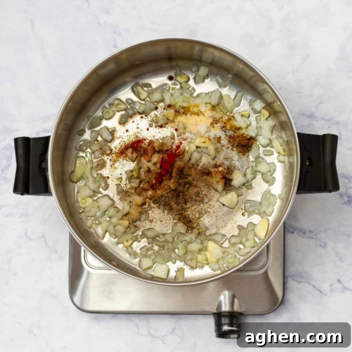 Aromatics (onions and garlic) and vibrant Mexican spices sautéing in a pan, filling the kitchen with a wonderful aroma.