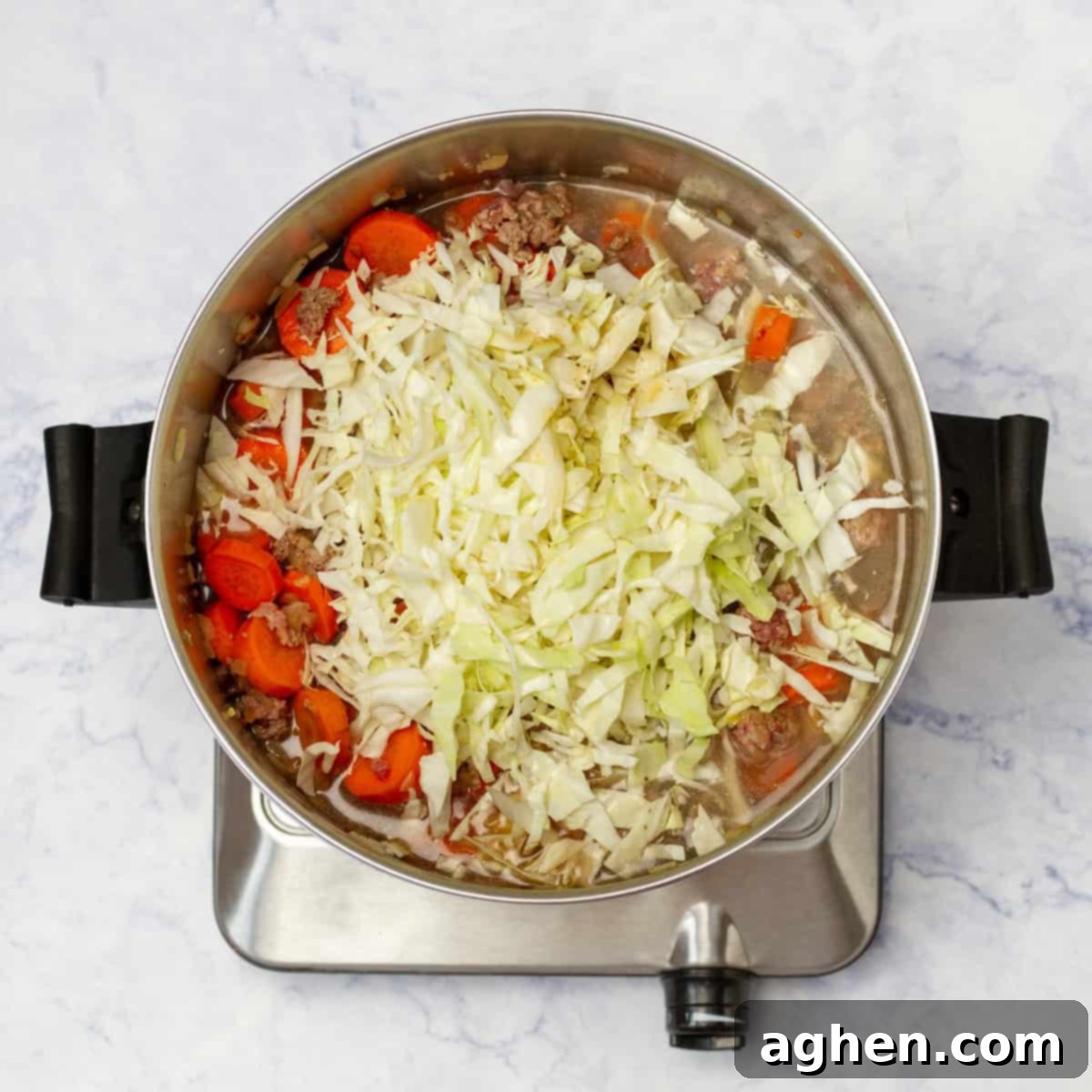 A rich, savory broth simmering gently with all the beautifully sauteed ingredients, including tender vegetables and flavorful ground beef, creating the deeply aromatic and comforting egg roll soup.