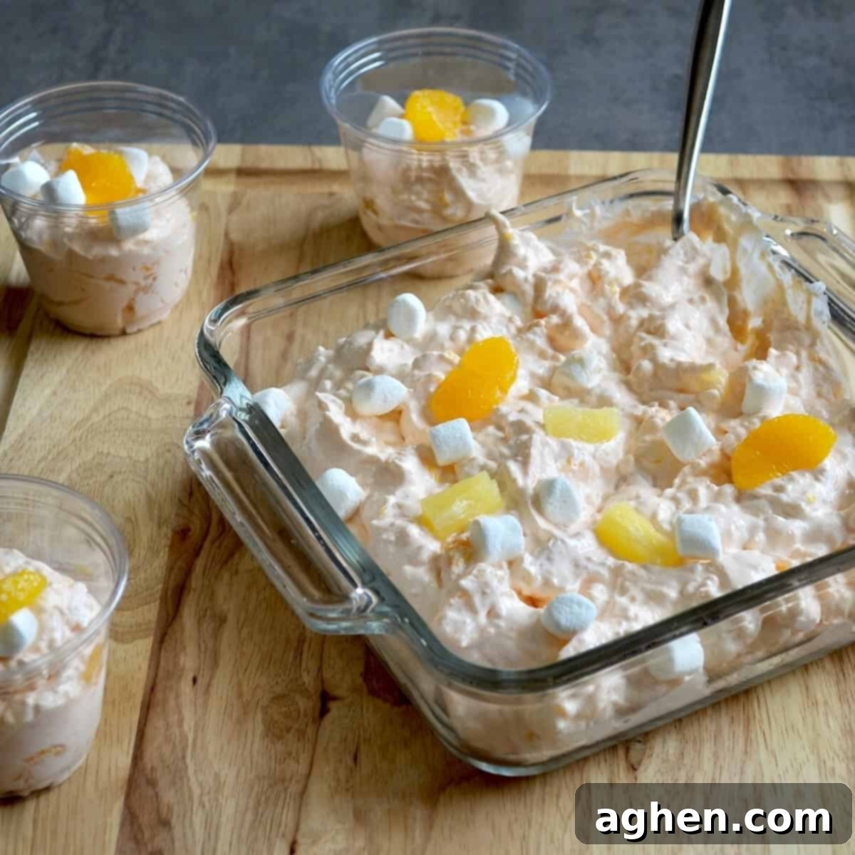Serving cottage cheese jello salad in a clear bowl with a spoon