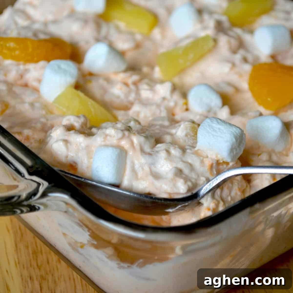 Scooping cottage cheese orange fluff into a serving bowl