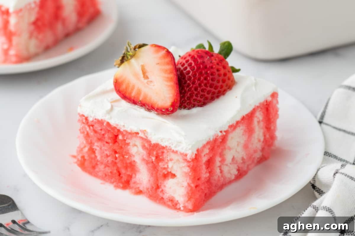 Strawberry jello poke cake with cool whip and fresh berries.