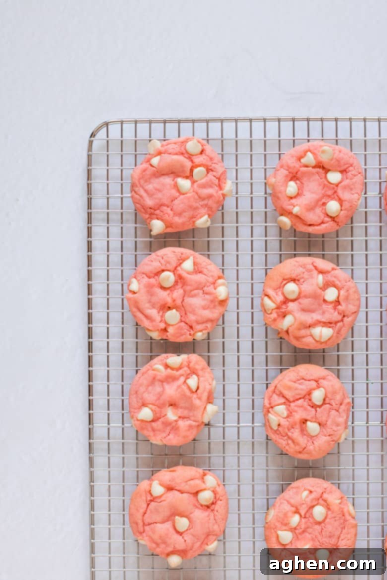 Simple Strawberry Cake Mix Cookies 4 Strawberry Cake Mix Cookies with White Chocolate Chips cooling on a wire rack.