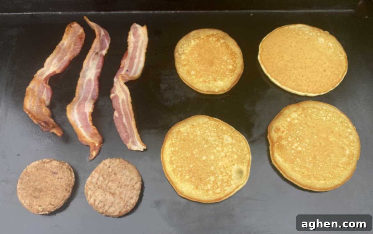 The Weber Griddle: Effortless Breakfast Grilling Starts Now 2 Sizzling bacon and scrambled eggs cooking on a Weber griddle on an outdoor grill.