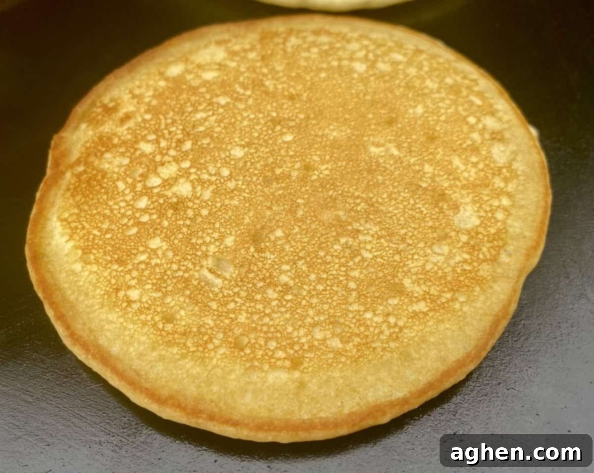 The Weber Griddle: Effortless Breakfast Grilling Starts Now 3 A selection of breakfast items including pancakes, bacon, and eggs cooking simultaneously on a large Weber flat top griddle.