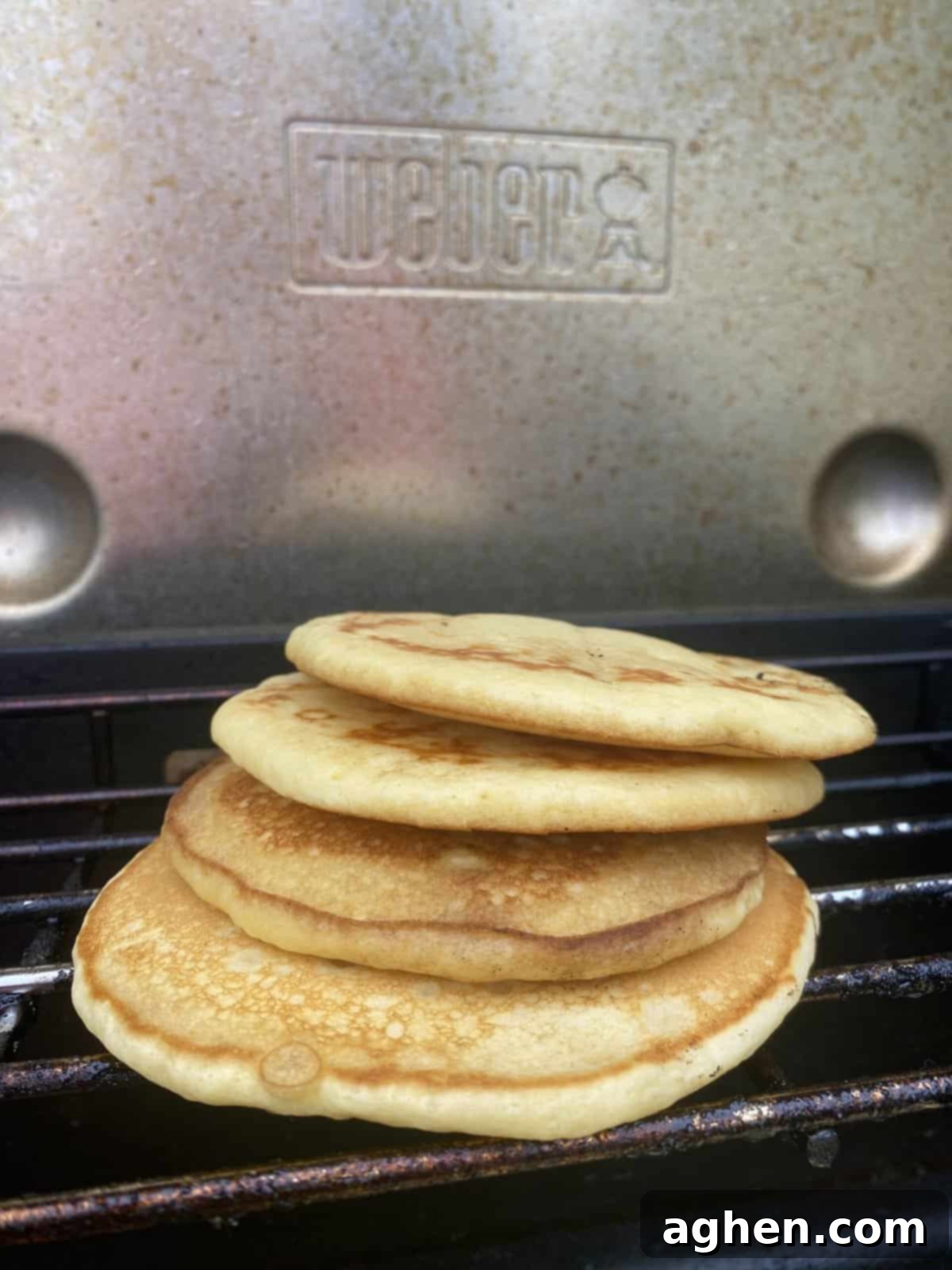 The Weber Griddle: Effortless Breakfast Grilling Starts Now 4 A stack of golden-brown fluffy pancakes topped with fresh berries and maple syrup.