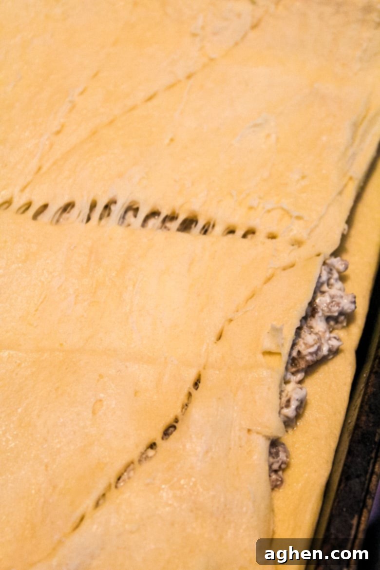 Second layer of crescent roll dough covering sausage and cream cheese mixture