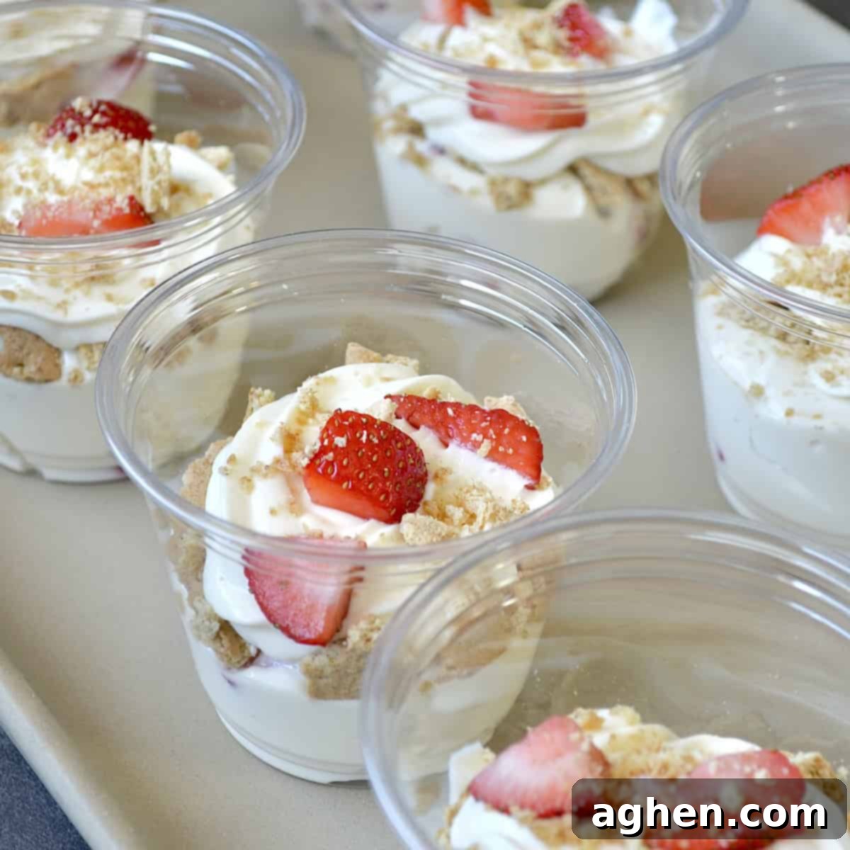 Weight Watchers' Legendary Cheesecake Fluff 2 Cheesecake cups with strawberries, garnished with fresh fruit and graham cracker crumbs, showcasing the creamy texture.