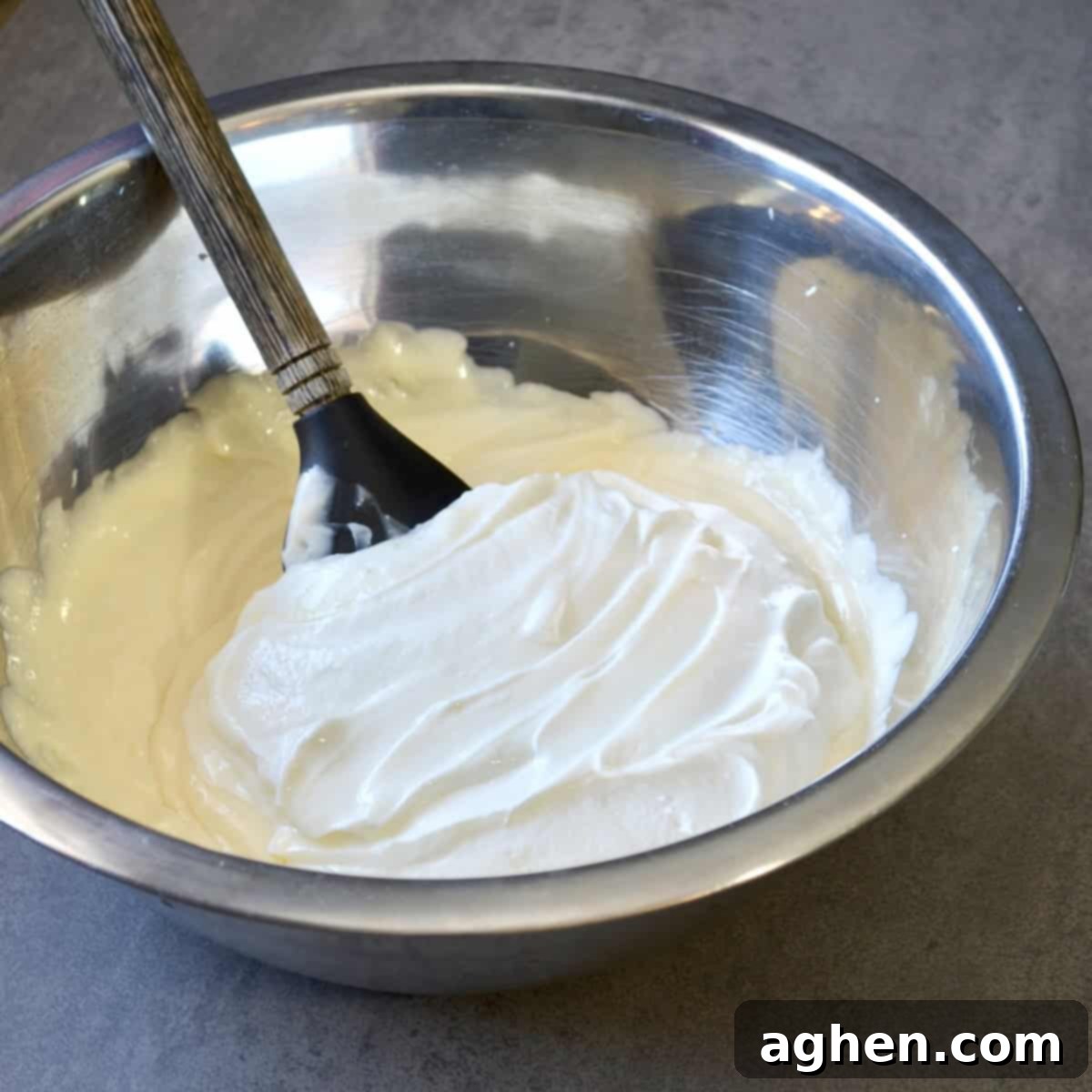 Weight Watchers' Legendary Cheesecake Fluff 5 A large bowl of creamy cheesecake fluff being mixed with a spatula, demonstrating the smooth texture.