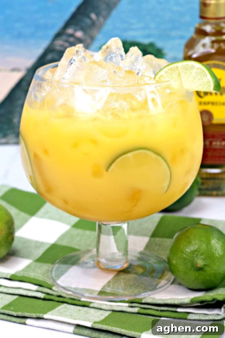 tropical cocktail with lime garnish and bottle of Jose Cuervo in background