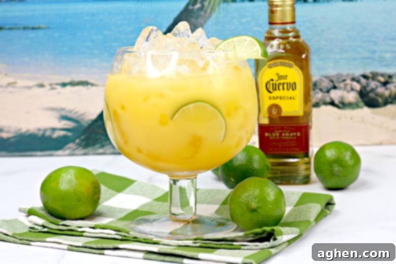 Hawaiian Margarita Cocktail with bottle of Jose Cuervo tequila and limes in background