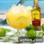 Hawaiian Margarita Cocktail with bottle of Jose Cuervo tequila and limes in background