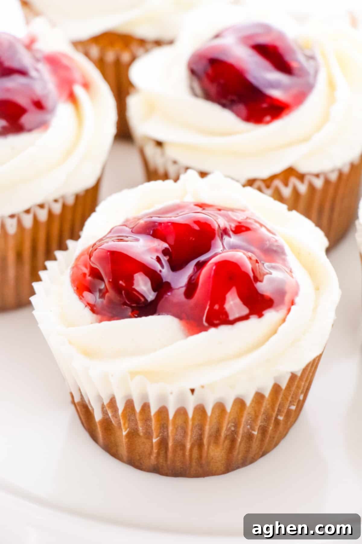 Cherry Pie Cupcakes with buttercream frosting and a visible cherry pie filling center, beautifully presented on a cooling rack.