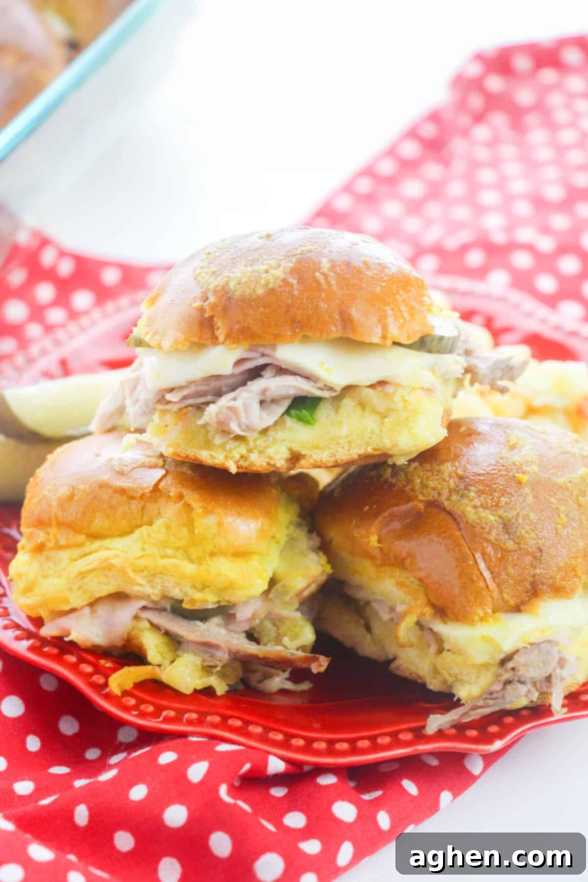 Cuban Slider sandwiches with pork, ham, swiss, pickles, and mustard on hawaiian rolls.