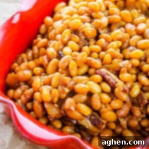 Boston baked beans with bacon in a red dish.