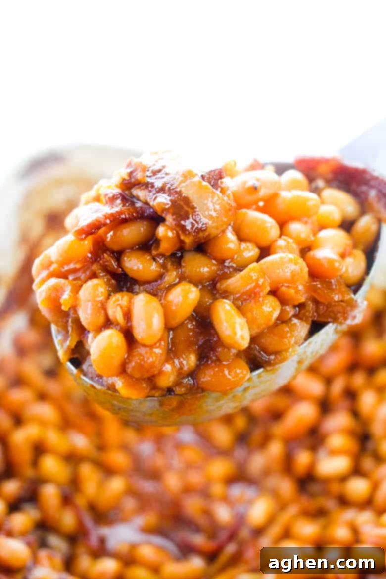 Serving spoon scooping out beans and bacon.