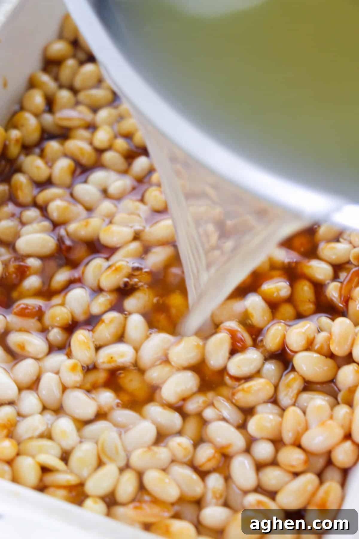 Bowl of water being poured in to bean dish.