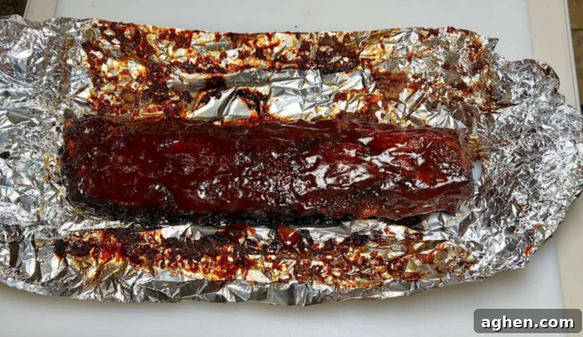 Baby back ribs on aluminum foil, ready for wrapping and saucing