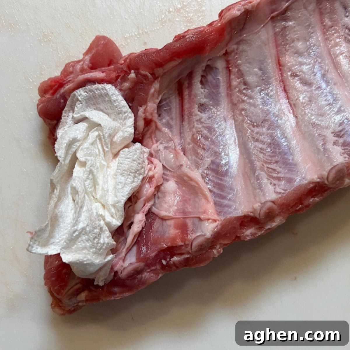 Pork membrane being peeled off with a paper towel