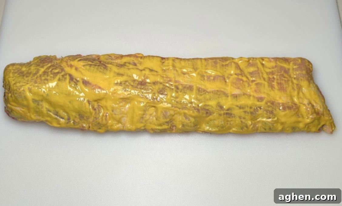 Close-up of mustard applied to baby back rib