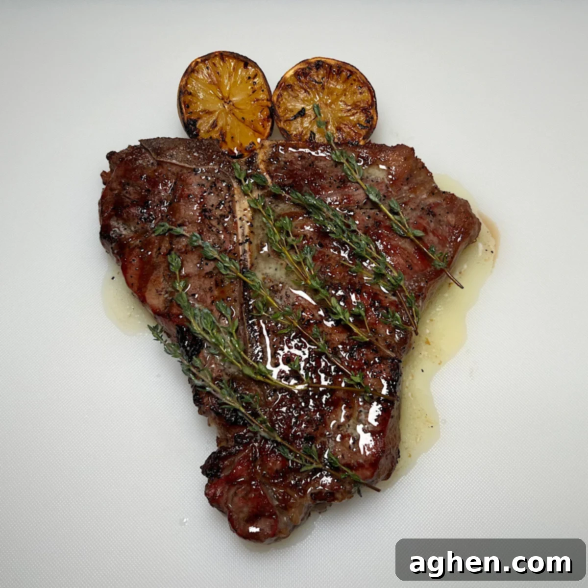 Master The Perfect Grilled Porterhouse Steak 2 Perfectly grilled porterhouse steak with two charred lemon halves, glistening with thyme butter