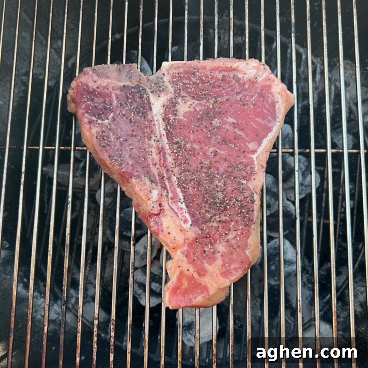 Master The Perfect Grilled Porterhouse Steak 6 Raw porterhouse steak cooking directly on a Weber Kettle grill grate