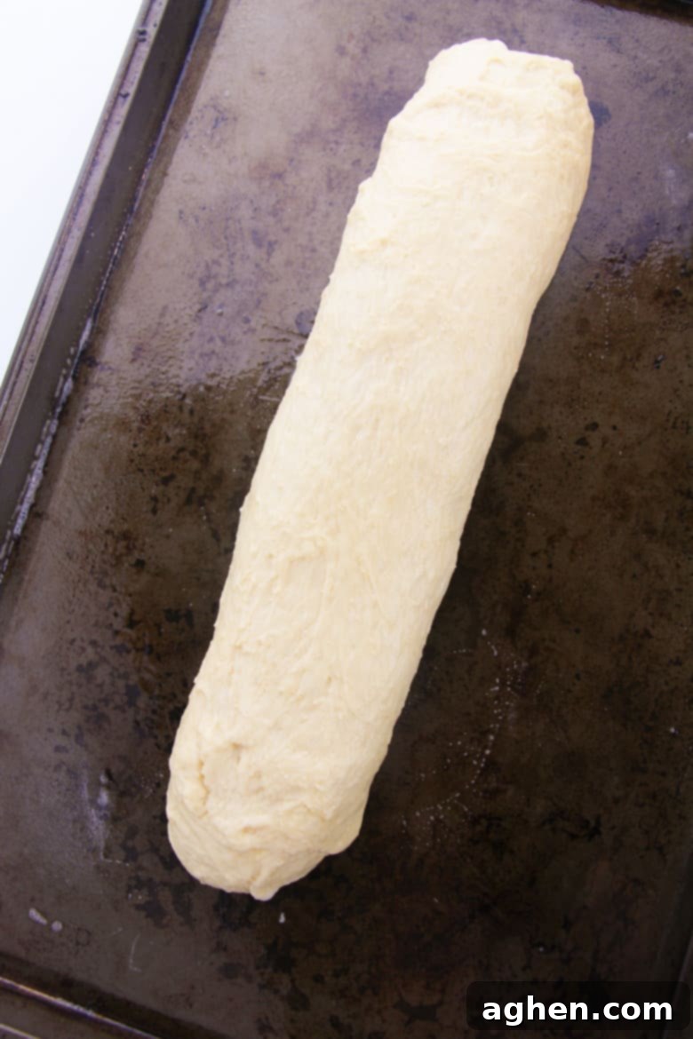 Bread dough formed into a long log on a baking sheet