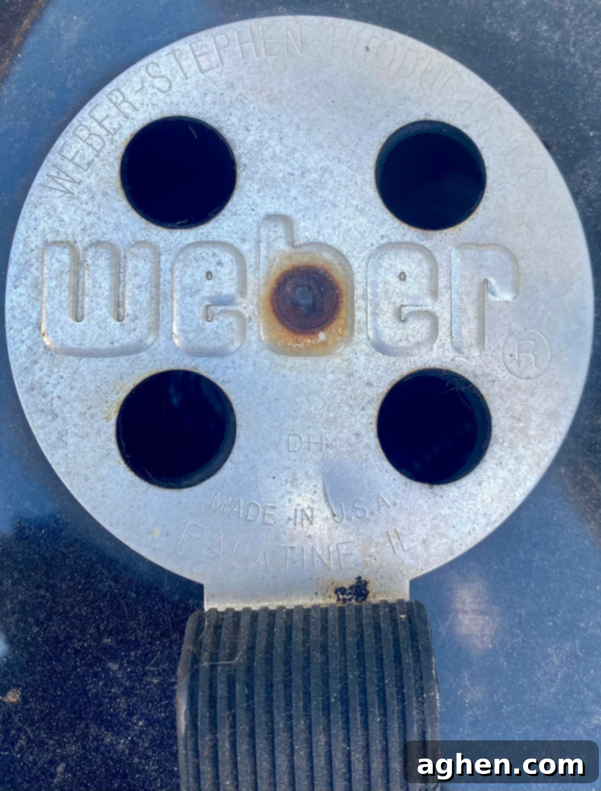 Adjusting the top and bottom vents of a Weber charcoal grill for temperature control.