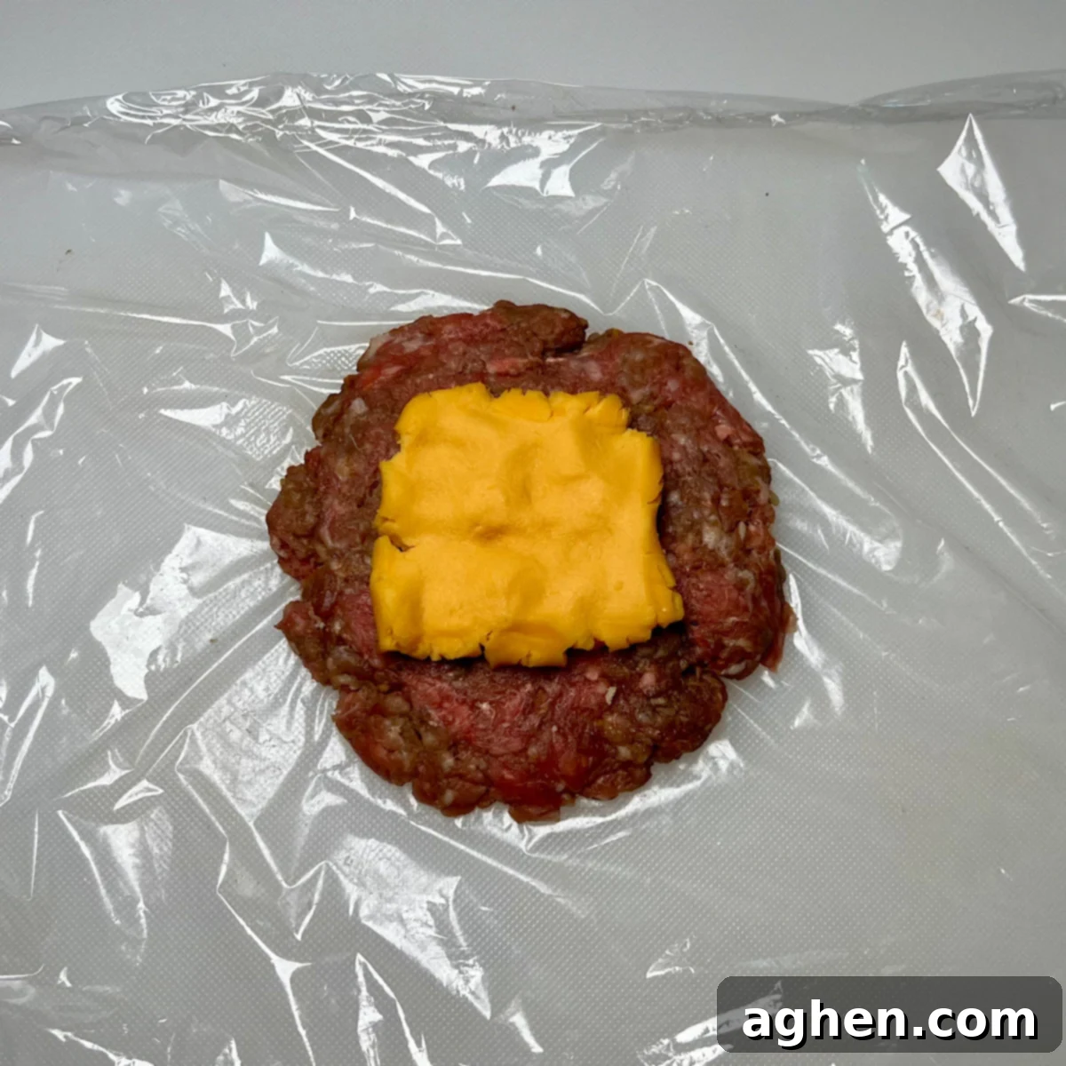 Smashed Juicy Lucy patty with a block of Velveeta cheese in the center