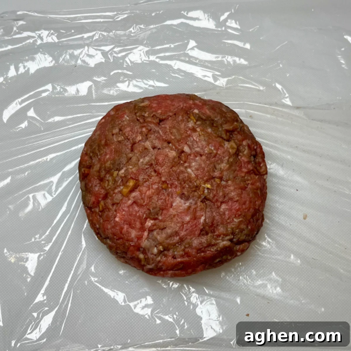 Finished raw Juicy Lucy burger patty, perfectly sealed and shaped