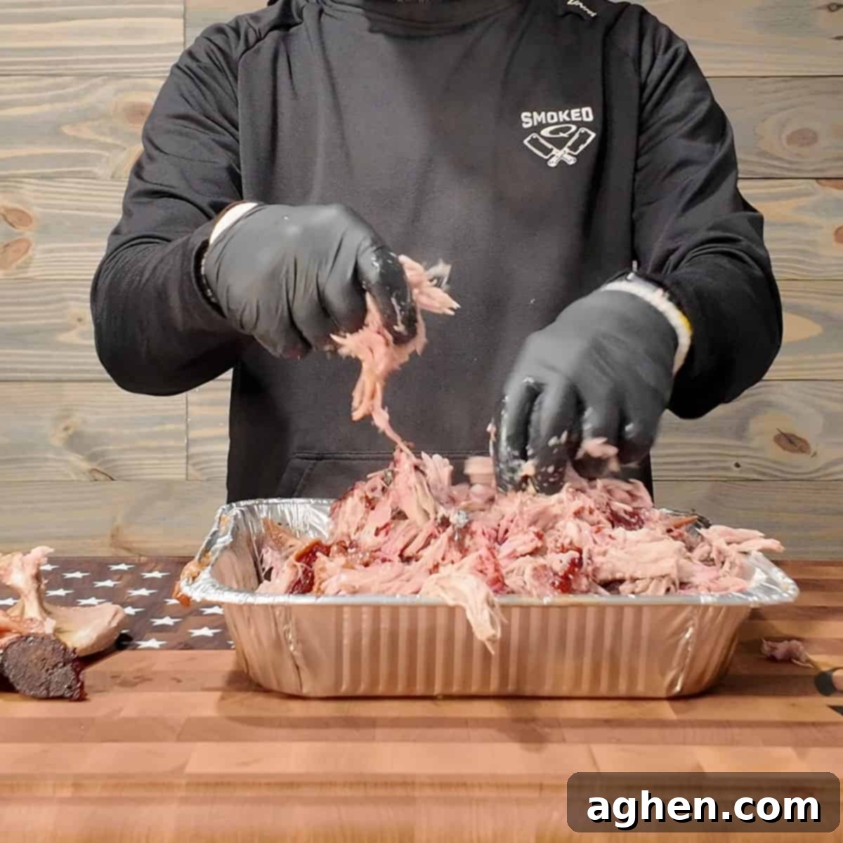 Traeger Pulled Pork being pulled, showing shredded, tender pork with a beautiful smoke ring, ready for serving.