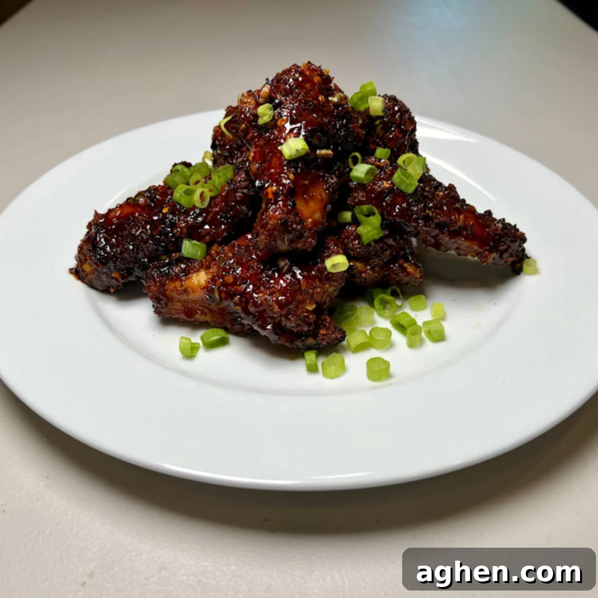 Plated finished chicken wings garnished with green onions