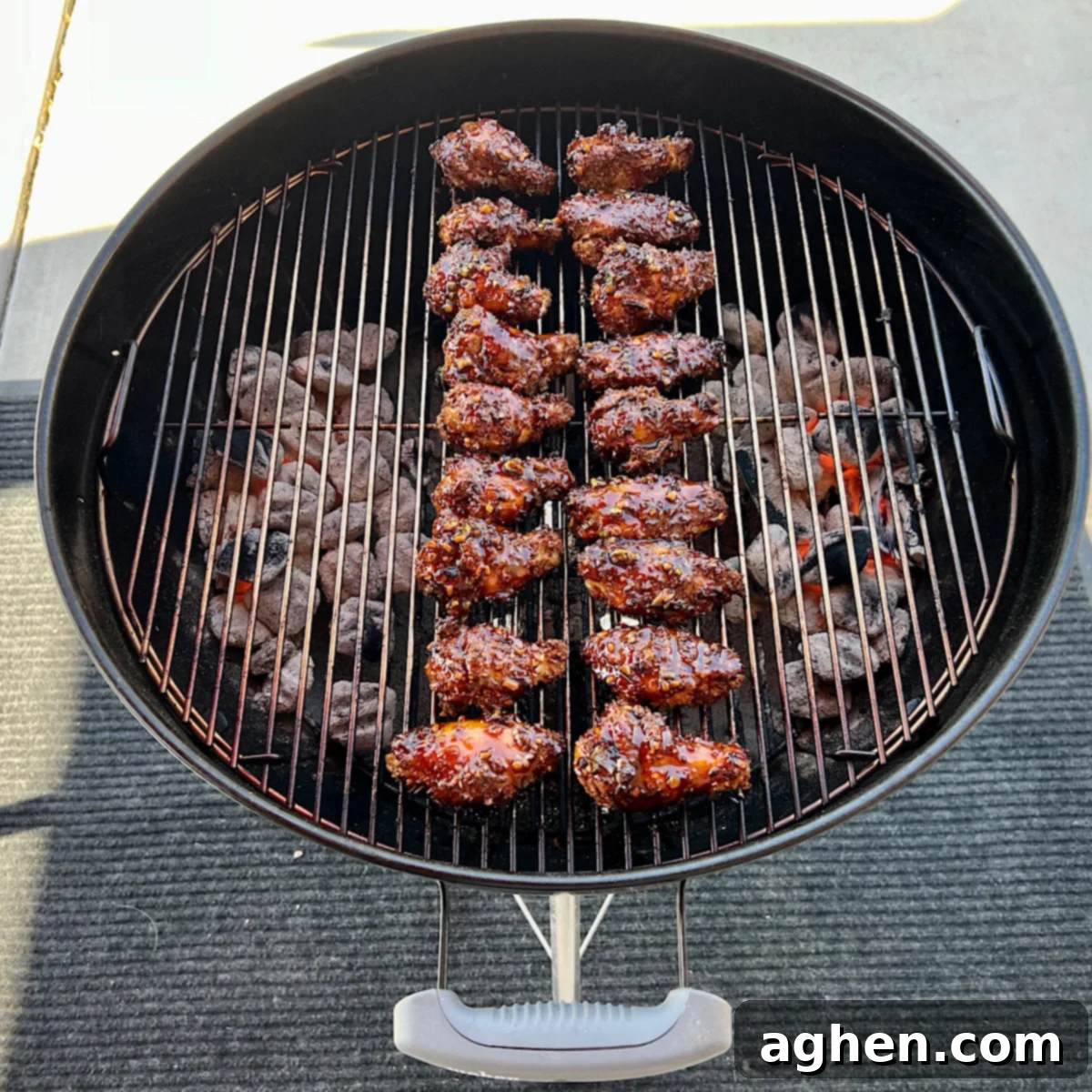 Finished glazed chicken wings on grill grate with char marks