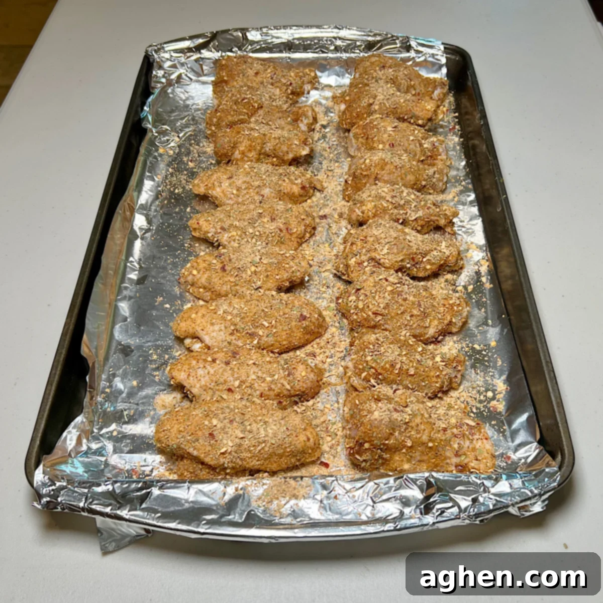 Chicken wings coated with rub on a tray