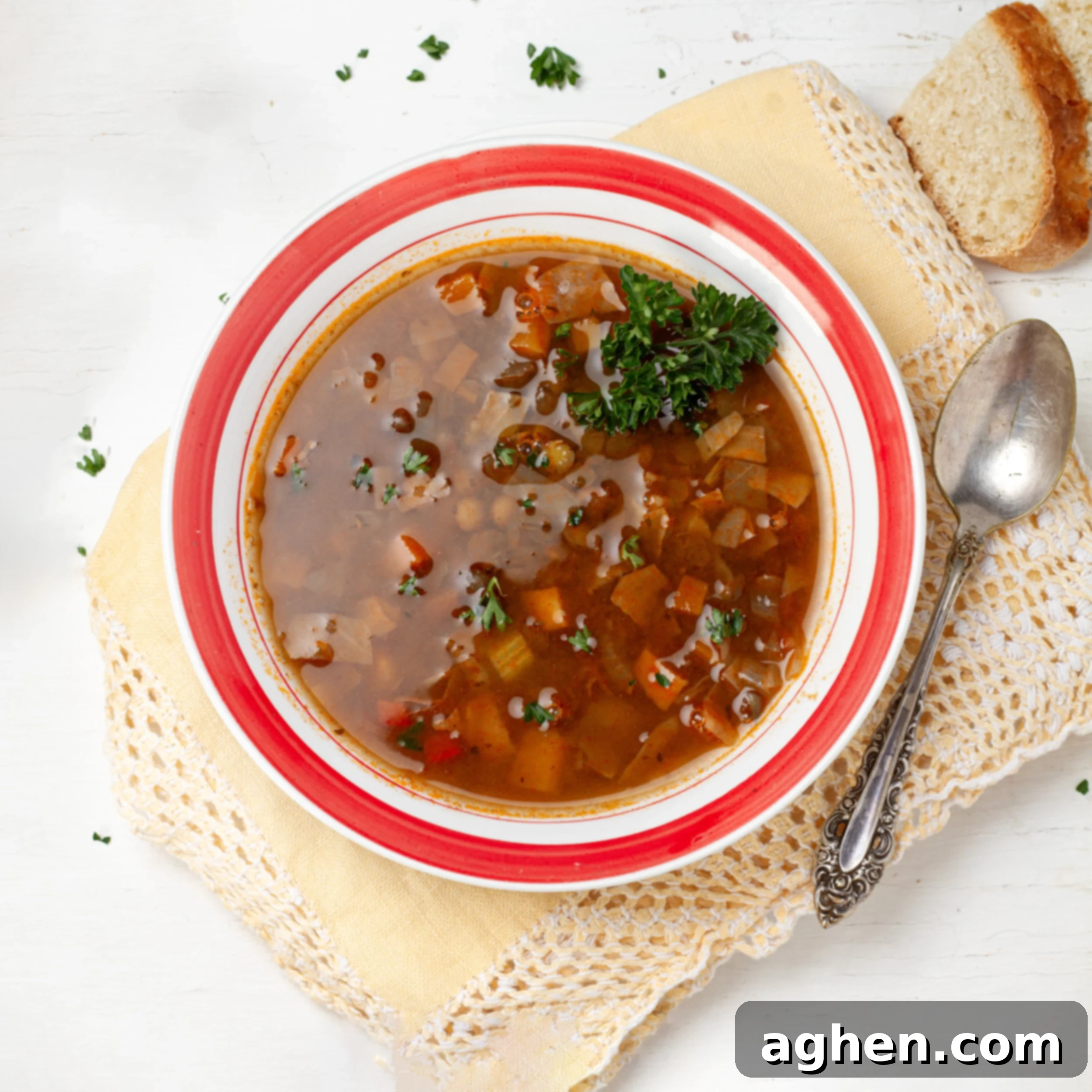 Lentil Cabbage Soup in a bowl with a spoon and a piece of bread.