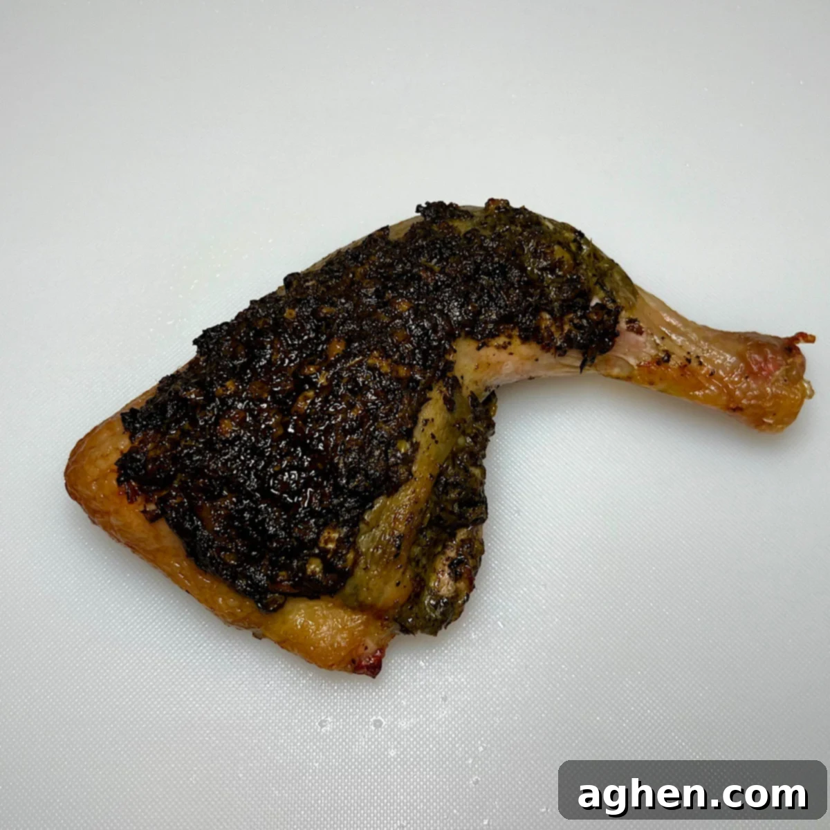 One perfectly grilled pesto chicken leg quarter, rested and ready to serve.