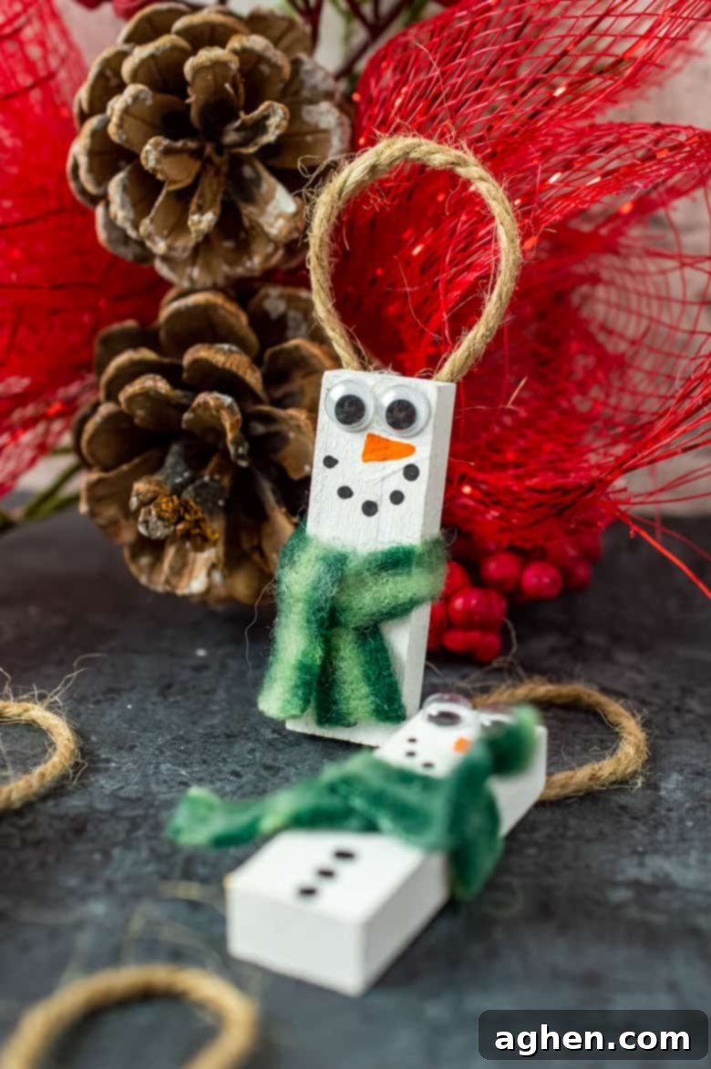 DIY Snowman Ornament made from Dollar Tree wood blocks, featuring a festive plaid scarf and hand-painted details.