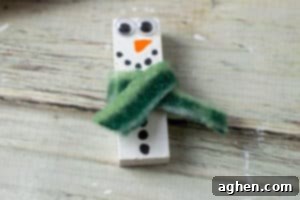 Wood block painted to look like snowman with a piece of fabric glued on to look like scraft