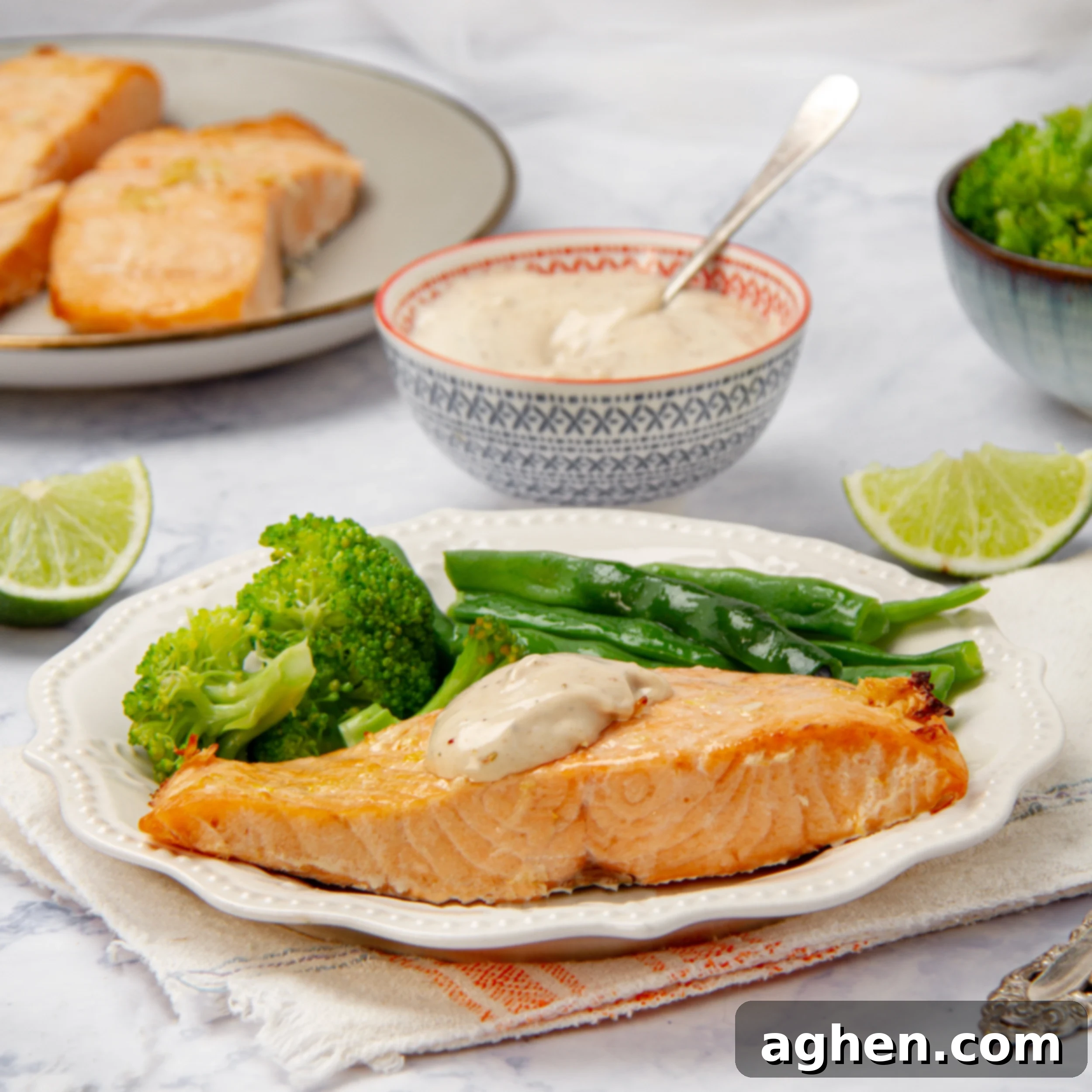 Air Fryer Salmon Perfection 2 Flakey and succulent Air Fryer Salmon filet on a plate with steamed vegetables and tartar sauce.