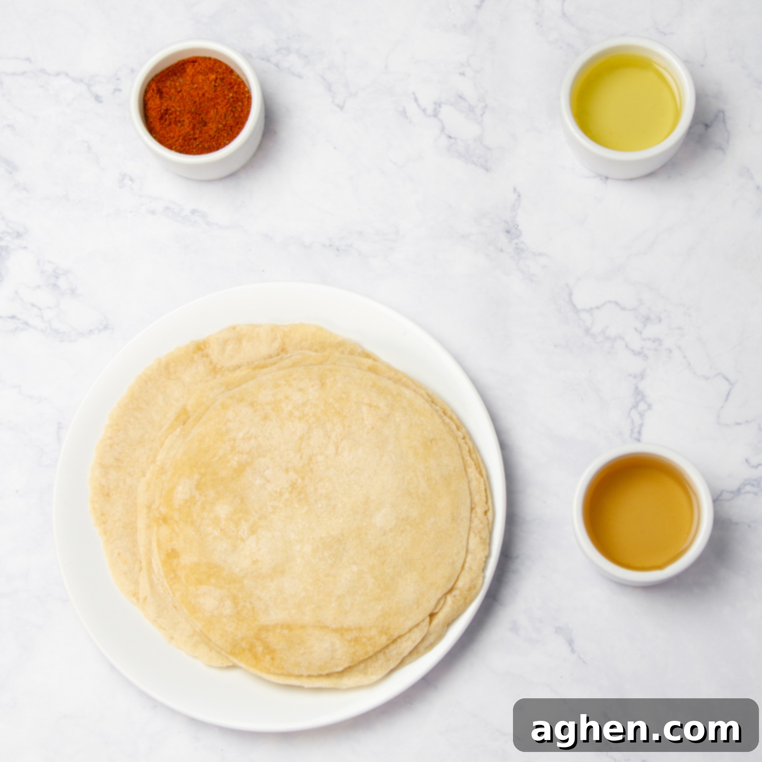 Weight Watchers Diyeti İçin Harika Ev Yapımı Tostitos Atıştırmalığı 3 Flour tortillas, seasonings, and oil in separate dishes on a counter, ready for assembly.
